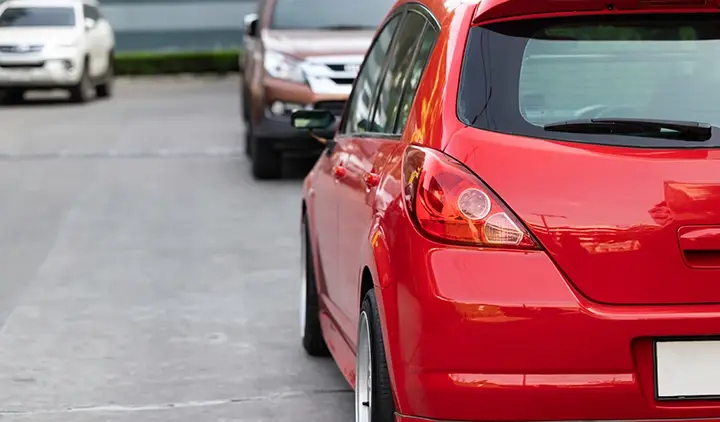 Kolme autoa parkkipaikalla