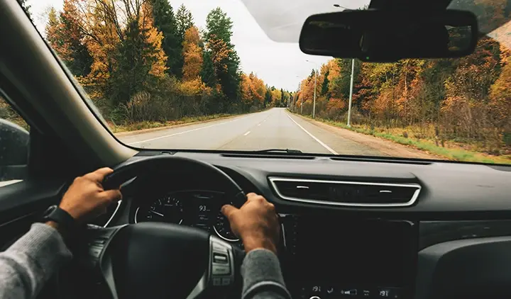 Auto ajaa autoa syksyisellä tiellä