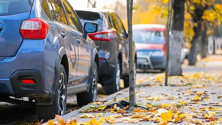 Kolme autoa pysäköitynä kadunvarressa