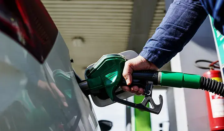 Ihminen tankkaa dieselautoa huoltoasemalla